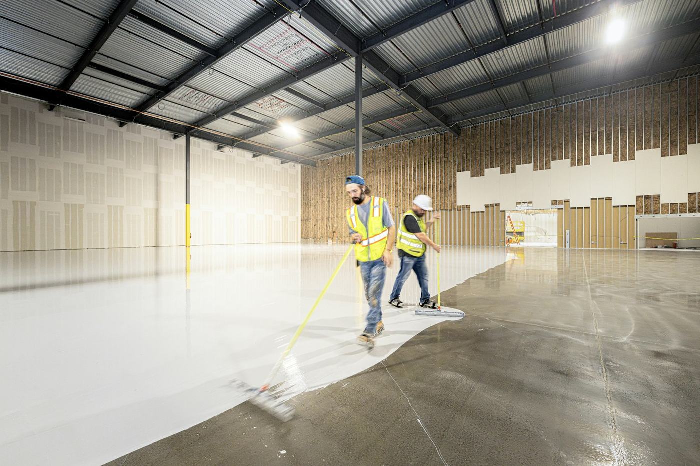 Crew squeegee-applying commercial epoxy flooring